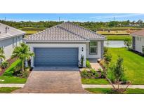 Beautiful single-Gathering home featuring a two-car garage, tile roof, and well-manicured landscaping at 10399 Abaco Falls Dr, Englewood, FL 34223