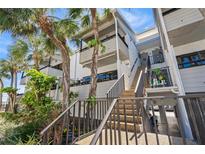 Inviting exterior view showcasing the staircase leading to units with charming balconies and lush landscaping at 1555 Tarpon Center Dr # 255, Venice, FL 34285