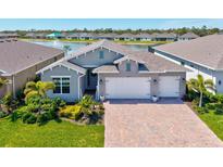 Beautiful single Gathering home with a 3 car garage, well manicured lawn, and gorgeous lake view at 1606 Cedar Valley Dr, Port Charlotte, FL 33953