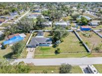 Aerial view of the home with a large yard, bordered with white fence at 2102 Alaric St, Port Charlotte, FL 33952