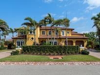 Stunning Mediterranean-style home with lush landscaping, a tile roof and a circular driveway at 416 Baycrest Dr, Venice, FL 34285