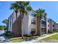 Condo exterior showcases a well-maintained building with lush landscaping and inviting screened-in balconies at 519 Albee Farm Rd # 116, Venice, FL 34285