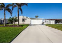 Charming single-Gathering home with a well-maintained lawn and palm trees in a sunny locale at 6037 Shearwater Dr, Englewood, FL 34224