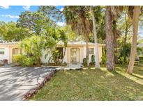 Charming single-story home with well-manicured lawn, mature tropical foliage, and inviting front entrance at 614 N Jefferson Ave # 27, Sarasota, FL 34237