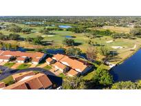 Stunning aerial view of a single-Gathering home on a lush golf course with pond and mature trees at 867 Country Club Cir #71, Venice, FL 34293