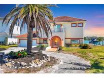Beautiful two-story waterfront home featuring a red tile roof, arched entryway, and lush landscaping at 919 Key Way, Nokomis, FL 34275