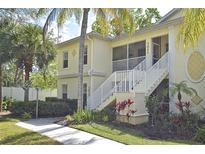 Inviting exterior showcasing the two-story home with well-manicured landscaping and white stair rails at 1000 Gardens Edge Dr # 1023, Venice, FL 34285