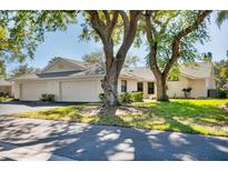 Charming single-story home featuring a neutral color, two-car garage, and mature trees at 109 Southampton N Pl # 245, Venice, FL 34293