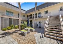Charming courtyard with stone benches and lush landscaping, providing a tranquil outdoor space at 200 Park N Blvd # 108, Venice, FL 34285