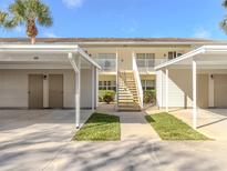 A view of the building exterior showcasing its architecture, landscaping, and covered parking with access to the units at 206 Silver Lake Dr # 105, Venice, FL 34292