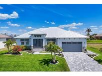 Beautiful single-story home featuring lush landscaping, a gray garage door, and a pristine white exterior at 226 W Pine Valley Ln, Rotonda West, FL 33947