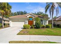 Charming single-story home with lush landscaping, a barrel tile roof, and a two-car garage at 2292 Harrier Way, Nokomis, FL 34275