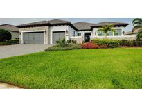 Attractive home exterior with a green lawn, mature landscaping, and a multi-car garage at 265 Bocelli Dr, Nokomis, FL 34275