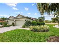 Inviting home exterior featuring a lush, landscaped yard, healthy lawn, and attached two car garage at 371 Capulet Dr, Venice, FL 34292