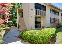 Charming condo with private staircase, lush landscaping, and a welcoming entrance at 5138 Harpers Croft # 12, Sarasota, FL 34235