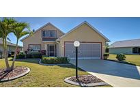 Charming single-Gathering home features a well-manicured lawn and beautiful landscaping at 589 Rose Apple Circle, Port Charlotte, FL 33954