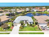 Stunning waterfront home with well-manicured lawn, lovely landscaping, and community water feature in the backyard at 863 Macaw Cir, Venice, FL 34285