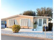Charming manufactured home with crisp exterior, white trim, and manicured landscaping at 937 Nettuno Dr, Venice, FL 34285