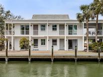 Waterfront condo building featuring a white exterior, multiple units and balconies, and a charming coastal aesthetic at 1001 Inlet Cir # 269, Venice, FL 34285