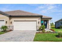 Charming home featuring a well-manicured lawn, paved driveway, and a two-car garage at 11239 Boundless Ter, Venice, FL 34293