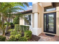 Elegant front door with decorative glass, framed by lush landscaping and a welcoming exterior at 1254 Cielo Ct, North Venice, FL 34275