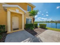 Inviting front entrance with well-maintained landscaping and a peaceful lake view at 12983 Tigers Eye Dr, Venice, FL 34292