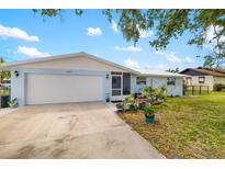 Charming single-story home with a well-manicured lawn, attached garage, and inviting front entrance at 1585 Keyway Ct, Englewood, FL 34223