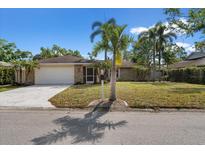 Charming single story home boasting a well-maintained lawn, stone accents, and a two-car garage at 214 Whispering Oaks Ct, Sarasota, FL 34232