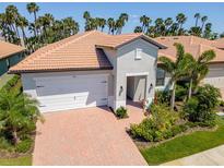 Charming single-Gathering home with lush landscaping, red tile roof, brick driveway and two car garage at 288 Soliera St, Nokomis, FL 34275