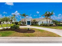 Charming single-story home featuring a manicured lawn, mature landscaping, and a welcoming double-door entrance at 351 Eden Dr, Englewood, FL 34223