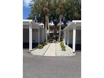 Condo exterior view showcasing palm trees, updated landscaping and assigned covered parking at 429 Cerromar Ln # 352, Venice, FL 34293