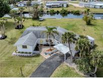 Charming waterfront home with lush landscaping, a covered carport, and easy access to the canal for boating and relaxation at 504 Buena Vista Dr, Nokomis, FL 34275