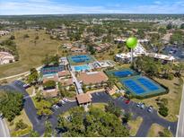 Expansive aerial view showcases a community with mature trees, tennis courts, pool, and well-maintained landscaping at 612 Bird Bay S Dr # 311, Venice, FL 34285