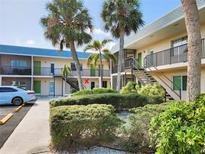 Inviting condo building with mature landscaping and a well-maintained facade and stairs to upper units at 616 Guild Dr # 2, Venice, FL 34285