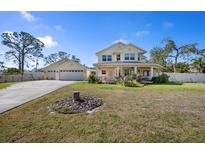 Beautiful two-story home with a long driveway, well-kept lawn, covered porch, and a detached garage at 915 Citrus Rd, Venice, FL 34293