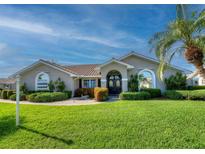 Charming single-story home with lush lawn, mature landscaping, and a welcoming front entrance at 1611 Valley Dr, Venice, FL 34292