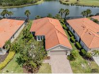 Beautiful single-story home with a red tile roof overlooking a scenic lake and golf course in a desirable community at 177 Treviso Ct, North Venice, FL 34275