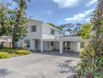Bright exterior of a two-story home featuring blue shutters and mature landscaping at 200 Sierra S St, Nokomis, FL 34275