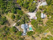 Expansive aerial view of an estate home with a resort-style pool, lush landscaping, and multiple outbuildings at 202 Laurel Oaks Rd, Nokomis, FL 34275