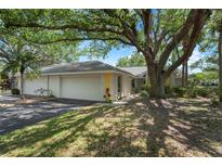 Charming single-story home featuring a lush yard, mature trees, and a two-car garage at 226 Southampton Ln # 257, Venice, FL 34293