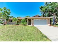 Charming single-story home with a well-manicured lawn, mature trees, and an attached two-car garage at 2641 Hyde Park St, Sarasota, FL 34239
