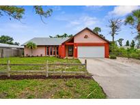 Charming single-story home with a two-car garage, colorful accents, and a well-manicured lawn at 304 Beach Rd, Venice, FL 34285