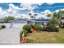 Charming home featuring a well-manicured lawn, landscaped garden, paved driveway and solar panels at 379 Peppertree Rd, Venice, FL 34293