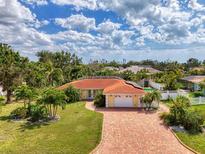 Stunning single-story home boasts a red tile roof, brick driveway, and lush landscaping at 403 Picasso Dr, Nokomis, FL 34275