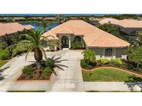 Stunning single-story home featuring a tile roof, lush landscaping, and a circular driveway at 4321 Via Del Santi Dr, Venice, FL 34293