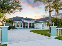 Beautiful blue home featuring an expansive driveway, well manicured lawn, and attached two-car garage at 5035 Collingswood Blvd, Port Charlotte, FL 33948