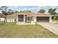 Charming single-story home featuring a well-maintained lawn and a screened front porch at 5417 Maccaughey Dr, North Port, FL 34287