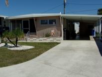 Charming single-story home featuring a carport, screened porch and quaint landscaping at 722 Carefree, Venice, FL 34285