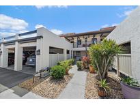 Townhouse exterior featuring stucco facade, carport, and lush landscaping at 764 Avenida Estancia # 212, Venice, FL 34292