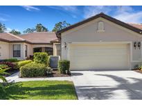 Charming home featuring a two-car garage, well-kept lawn, and lush landscaping at 11007 Batello Dr, Venice, FL 34292
